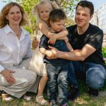 Family of four enjoying a sunny day outdoors in Kemer, smiling and spending quality time together.